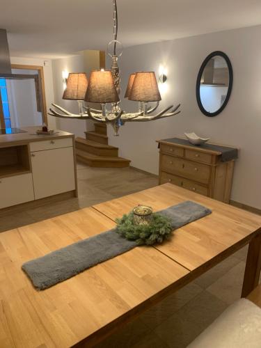 a living room with a table and a mirror at Altenhauser Hof in Kössen