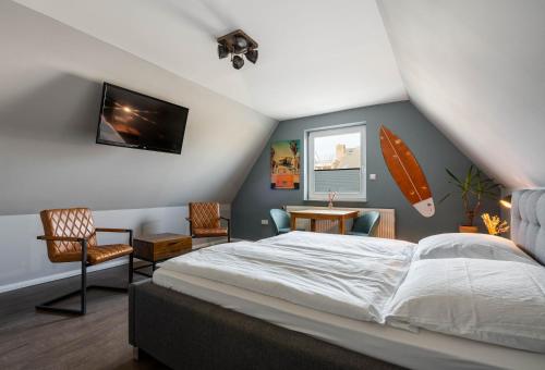 a bedroom with a bed and a surfboard on the wall at Hotel Luina Beach in Büsum
