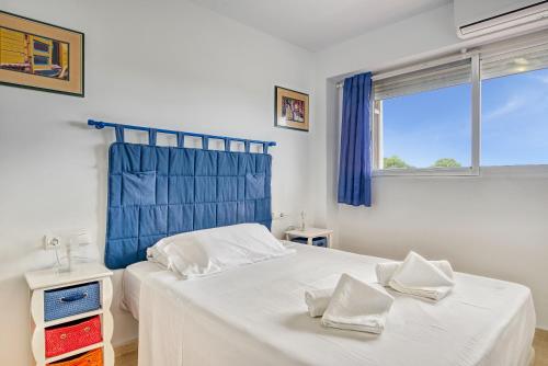 een slaapkamer met een bed met een blauw hoofdeinde en een raam bij Los Molinos in Denia