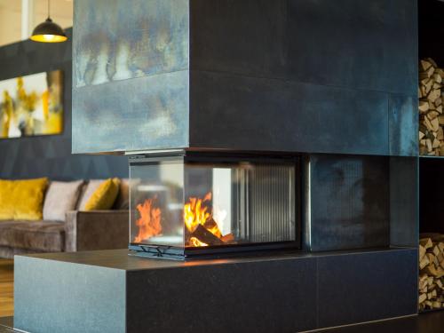 a fireplace in a living room with a couch at Best Western Parkhotel Hagenberg in Hagenberg im Mühlkreis