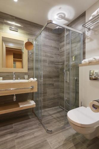 a bathroom with a shower and a toilet and a sink at AmstelSki in Bukovel