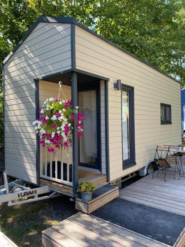 una casa pequeña con flores en una cubierta en Tiny House Ruhr im PIER9 Tiny House Hotel, en Hamm