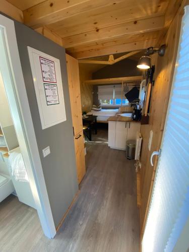 a hallway leading into a tiny house with a kitchen at Tiny House Ruhr im PIER9 Tiny House Hotel in Hamm