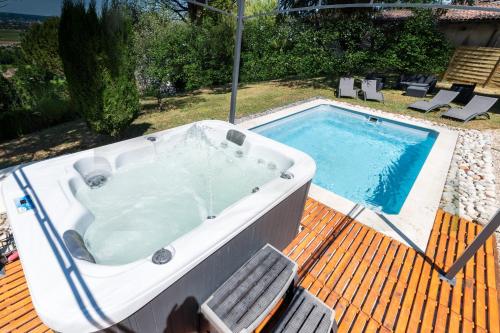 - un bain à remous installé sur une terrasse à côté d'une piscine dans l'établissement Maison Monbazillac avec piscine 2-4 pax, à Monbazillac