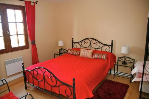 een slaapkamer met een rood bed en een rode deken bij Maison Monbazillac avec piscine 2-4 pax in Monbazillac