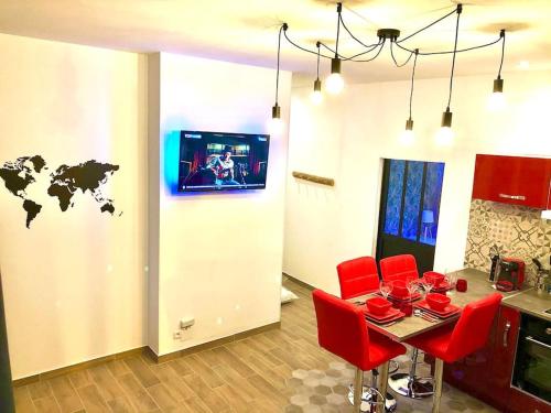 eine Küche mit einem Tisch mit roten Stühlen und einer Weltkarte an der Wand in der Unterkunft Le Led Room,Centre ville place de parking gratuite in Sens