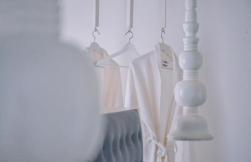 a rack of white shirts and a lamp in a room at W15 Escape in Ahangama