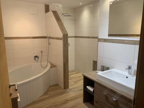 een badkamer met een bad en een wastafel bij Altenhauser Hof in Kössen