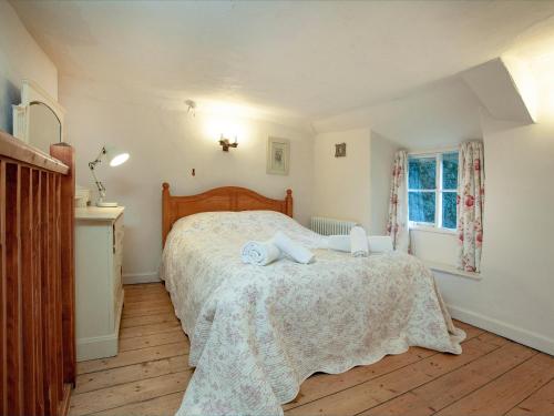 a bedroom with a bed with two towels on it at Yew Tree Cottage in Branscombe