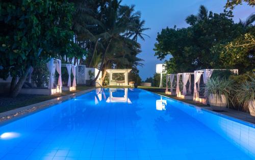 a swimming pool at night with blue water at W15 Escape in Ahangama