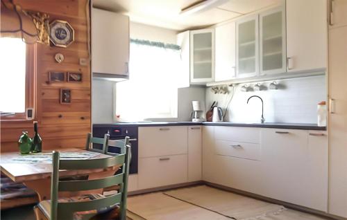 モーレイにあるStunning Home In Mly With Kitchenのキッチン(白いキャビネット、テーブル、シンク付)