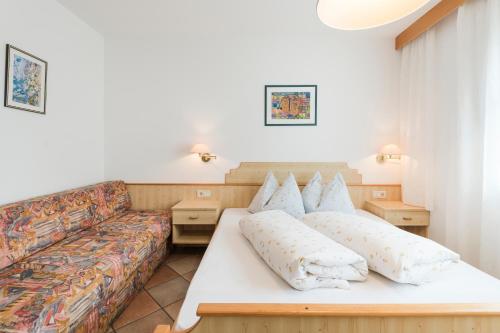 een woonkamer met een bank en een bed bij Residence Am Wegkreuz in Senales