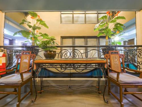 a table and chairs with plants on a balcony at Super OYO Capital O 907 Ceo Flats in Manila