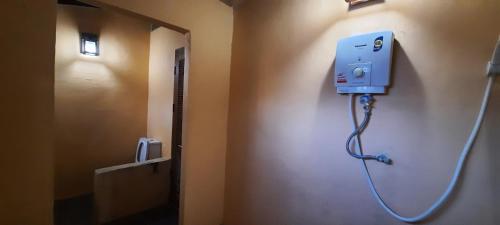 a bathroom with a hose hooked up to a wall at Mountainblues in Kampong Huaibū
