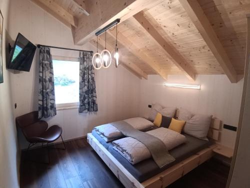 ein Schlafzimmer mit einem Bett und einem Stuhl darin in der Unterkunft Ferienhaus Oberschindlberg in Lunz am See
