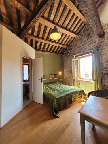 ein Schlafzimmer mit einem grünen Bett in einem Zimmer mit einem Tisch in der Unterkunft Casa Acqua Dolce - House with 4 Bedrooms and Own Spa in Oprtalj