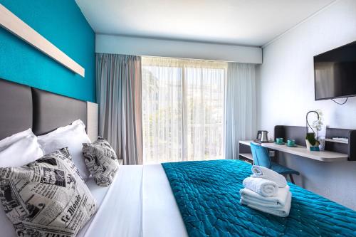 ein Hotelzimmer mit einem Bett und einem Fenster in der Unterkunft Hôtel Jardin Croisette in Cannes