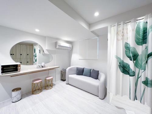 uma sala de estar branca com um sofá e uma mesa em 婧仕女微旅 em Hou-lung-tzu