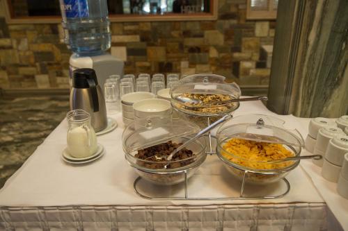 a buffet with three bowls of food on a table at Hotel Liberty in Mesolongion