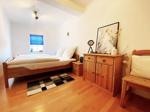 a bedroom with a bed and a dresser and a chair at Appartement DOM I - Erfurt Domplatz in Erfurt