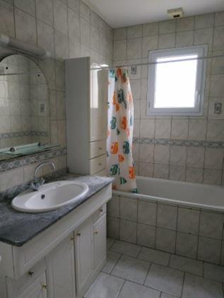 a bathroom with a sink and a tub and a window at Pavillon 6 personnes in Corgirnon