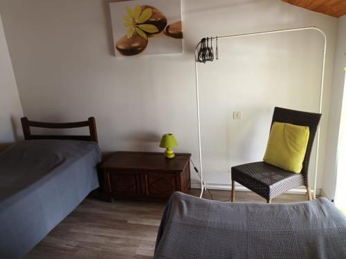 1 dormitorio con 1 cama y 1 silla con almohada amarilla en Gîte d'étape Zuharpeta Randonneur Pèlerin, en Saint-Jean-Pied-de-Port