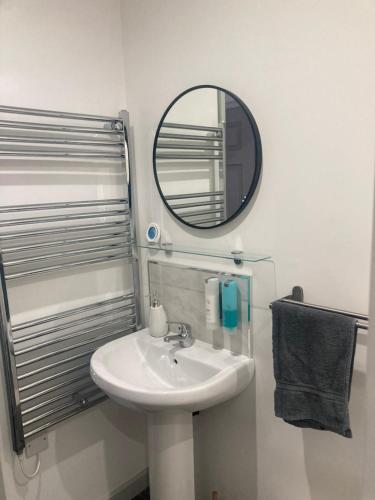 La salle de bains est pourvue d'un lavabo et d'un miroir. dans l'établissement Lancing Apartments - Spacious 2 Bed - Sleeps 6 - Burnham Village, à Slough