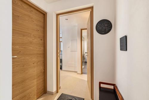 un pasillo con una puerta que conduce a una habitación en Planerhof Apartment Lilie, en Funes