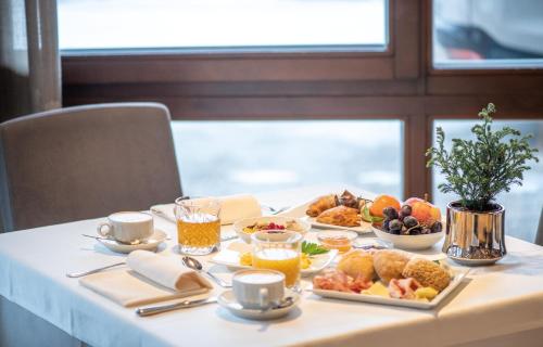 a table with breakfast foods and drinks on it at Hotel Condor in San Vigilio Di Marebbe