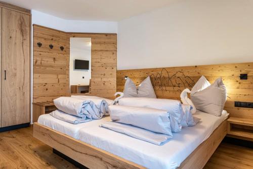 1 dormitorio con 2 camas y almohadas blancas en Planerhof Apartment Lilie en Funes