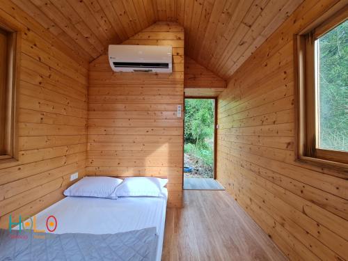a bedroom in a wooden cabin with a bed in it at Les Bois BaVi by HOLO Serviced HomeStay in Hanoi