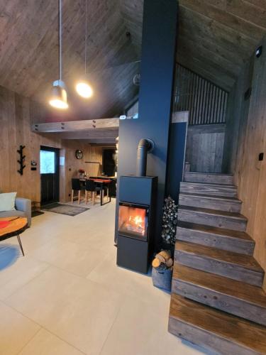 a living room with a fireplace and a staircase at Wimer Domki in Wysowa-Zdrój