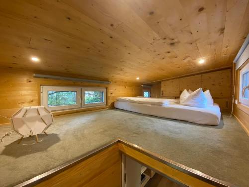 1 dormitorio en una cabaña de madera con 1 cama. en Tiny House Wupper im PIER9 Tiny House Hotel, en Hamm