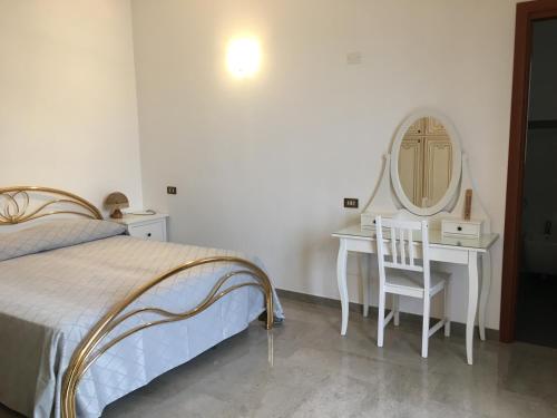 1 dormitorio con cama, tocador y espejo en L'isola di Francesca, en Conversano
