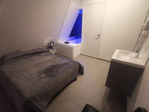 a bedroom with a bed and a bathroom with a sink at Hotel-Chao NL 24 hours open in Utrecht