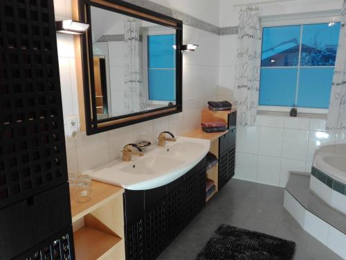 a bathroom with a sink and a mirror and a tub at Appartement Juffinger in Thiersee