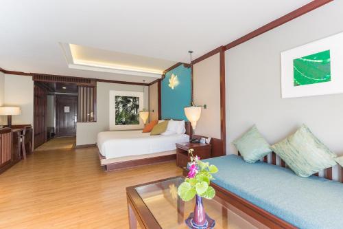 a room with two beds and a vase with flowers on a table at Beyond Samui in Chaweng