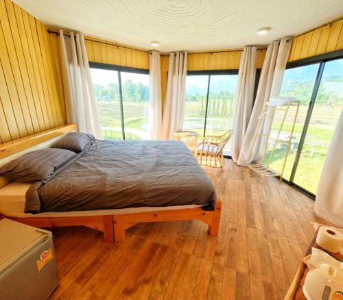 sypialnia z łóżkiem w pokoju z oknami w obiekcie ดูดอยคอยดาว Dodoykoydao 