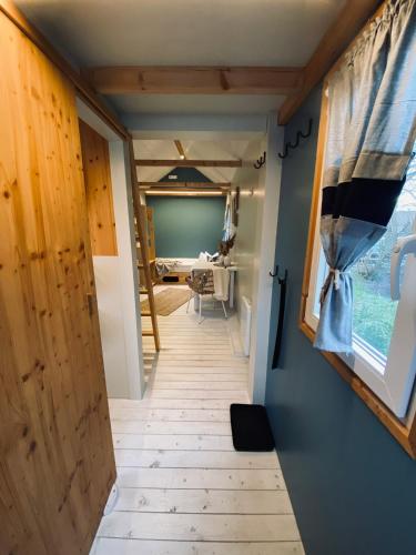 a hallway leading to a room with a table at Tiny House Werse im PIER9 Tiny House Hotel in Hamm