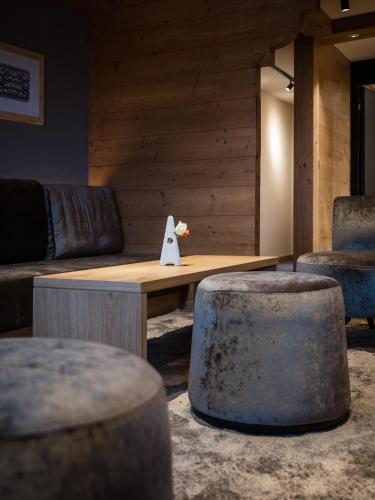 a room with a couch and a table and two stools at Panorama Hotel & Restaurant in Bettmeralp