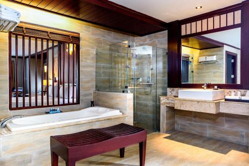 a bathroom with a tub and a shower and a sink at Beyond Samui in Chaweng