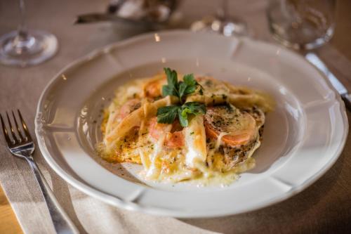a plate of pasta with meat and cheese on a table at Panorama Hotel & Restaurant in Bettmeralp