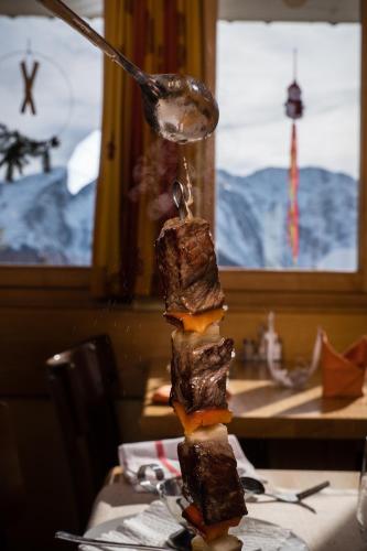 a spoon with a piece of food on a table at Panorama Hotel & Restaurant in Bettmeralp
