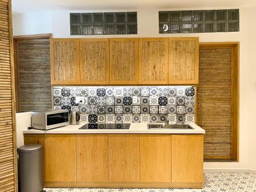 a kitchen with wooden cabinets and a microwave at Song Anh Indochina Studios Pasteur in Ho Chi Minh City