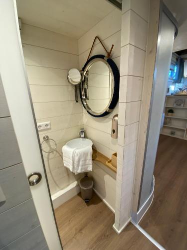 a small bathroom with a mirror and a sink at Tiny House Ems im PIER9 Tiny House Hotel in Hamm