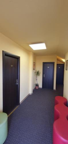 an empty room with two doors and red chairs at Forest Inn in Izvorani