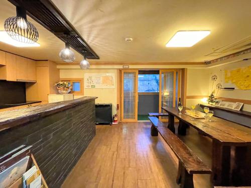 ソウルにあるココア ゲストハウスのバー、テーブル、ベンチが備わる広い客室です。