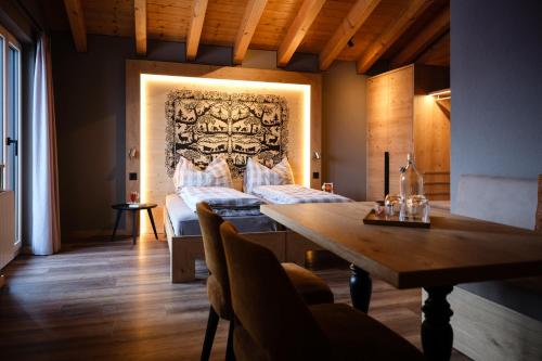 een kamer met 2 bedden en een houten tafel bij Panorama Hotel & Restaurant in Bettmeralp