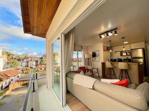 sala de estar con sofá y ventana grande en Apartamentos Solar da Garibaldi CENTRO by Achei Gramado, en Gramado