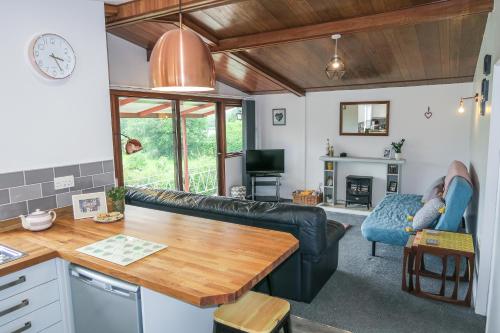 ein Wohnzimmer mit einem Sofa und einem Tisch in der Unterkunft Riverside Chalet in heart of Lampeter, West Wales in Lampeter